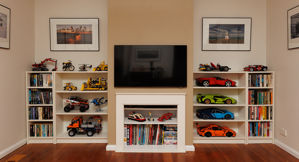 End wall of my lounge, 43" television mounted in the centre, shelves with lego and books on either side